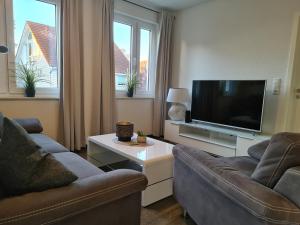 a living room with two couches and a flat screen tv at Ihr Ostseedomizil, im Ortskern von Kellenhusen, strandnah und mittendrin in Kellenhusen