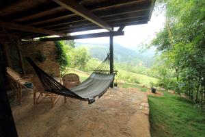 a hammock on a patio with a view of a mountain at Lands End Kandy in Kandy