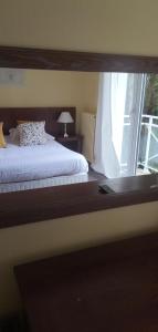 a bedroom with a bed and a large window at Hotel Le Rivage in Olivet