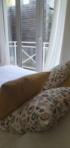 a bed with pillows in front of a window at Hotel Le Rivage in Olivet