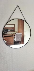 a mirror reflecting a room with a desk and a chair at Hotel Le Rivage in Olivet