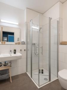 a bathroom with a glass shower and a sink at limehome Trier Nikolaus-Leis-Straße in Trier