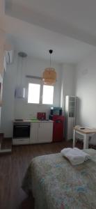 Habitación con cama y cocina con ventanas. en Apartamentos El Alcazar de Jerez, en Jerez de la Frontera