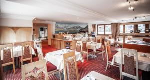 ein Restaurant mit Tischen und Stühlen und eine Küche in der Unterkunft Ferienhaus Austria in Sölden