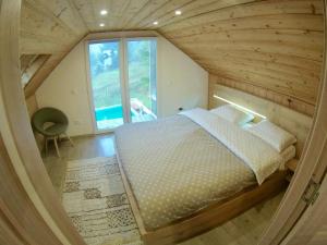 ein großes Bett in einem Zimmer mit einem großen Fenster in der Unterkunft Cabana Mia Parang in Petroşani