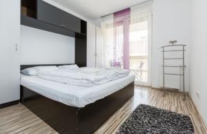 Mentha Apartments Deluxe - MAD في بودابست: غرفة نوم مع سرير كبير مع اللوح الأمامي الأسود