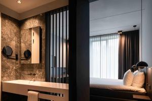 a bedroom with a bed and a sink and a mirror at Hotel & Wellness Zuiver in Amsterdam