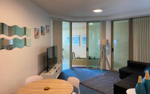 a living room with a couch and a tv at Mooloolaba Beachfront: Superior Resort Apartment in Mooloolaba