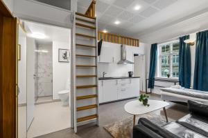 a living room with a spiral staircase and a kitchen at Esbjerg BB hotel in Esbjerg