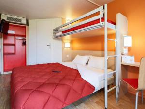 - une chambre avec des lits superposés et un couvre-lit rouge dans l'établissement Première Classe Epinay Sur Orge Savigny Sur Orge, à Épinay-sur-Orge