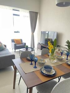 uma sala de estar com uma mesa de madeira com pratos e copos em The Ridge Twiinz.Inn @ KL East em Kuala Lumpur