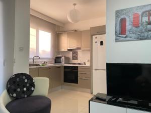 a kitchen with a chair and a tv in a room at Girne Merkez Cozy 2+1 Daire wifi +netflix in Kyrenia