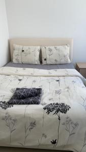 a bed with a white comforter with birds on it at Girne Merkez Cozy 2+1 Daire wifi +netflix in Kyrenia