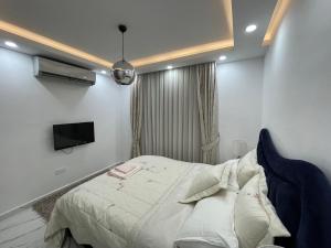 Un dormitorio con una cama y un televisor en la pared. en Elegant 2+1 Flat in the Heart of Kyrenia + wifi, en Kyrenia