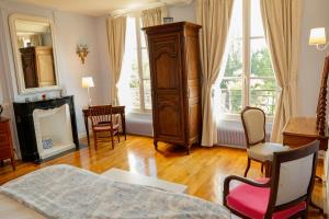 a bedroom with a bed and a dresser and a chair at Chambres d'hôtes du Bas Manoir in Bretteville-sur-Odon