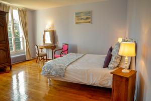a bedroom with a bed and a table and chairs at Chambres d'hôtes du Bas Manoir in Bretteville-sur-Odon