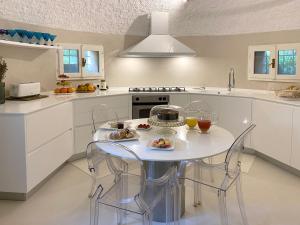a white kitchen with a table and chairs in it at Villa Lina in Tremezzo