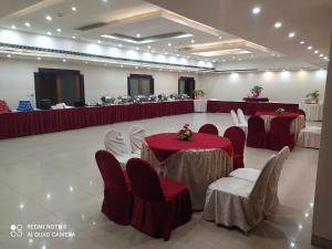 a banquet hall with red and white tables and chairs at SHELTER HOTEL in Lucknow