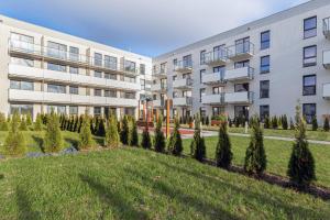 an apartment building with trees in front of it at Nadmorskie Tarasy Gdynia by Renters in Gdynia
