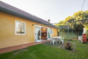 ein gelbes Haus mit einem Tisch und Stühlen im Hof in der Unterkunft Villa Patrice in Massa