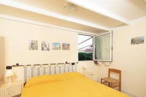 een slaapkamer met een geel bed en een raam bij Villa Patrice in Massa