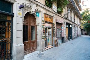 um edifício com uma grande porta de madeira numa rua em Hostal Hera em Barcelona
