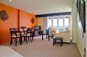 a living room with orange walls and a table and chairs at Willis Village in Wellington