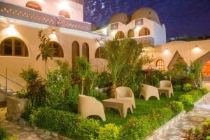 a courtyard of a building with chairs and plants at Janat Elsahara Hotel in Luxor