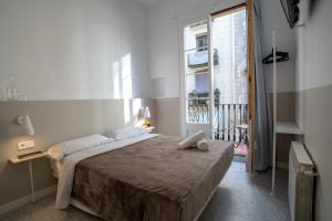 a bedroom with a large bed and a window at Hostal Hera in Barcelona