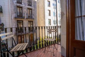 a balcony with a bench and a fence with buildings at Hostal Hera in Barcelona +23 photos