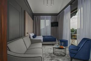 a hotel room with a couch and a bed at Hotel & Restauracja Gniecki in Hrubieszów
