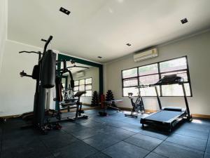 a gym with several tread machines and a tv at Na Mantra Resort in Chiang Mai