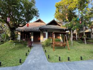 a house with a playground in front of it at Na Mantra Resort in Chiang Mai