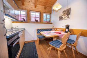 a kitchen with a table and chairs and a sink at Gemütliche Ferienwohnung Bergwiese, 2-Raum, separates Schlafzimmer, schönen Balkon oder Terrasse, Komfort Ausstattung, ruhige Südlage, kostenfrei WLAN, Sauna im Landhaus, Brötchenservice, Parkplatz, Hunde auf Anfrage, E-Tankstelle,Barbaras Wanderheft incl in Balderschwang