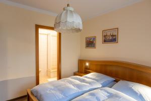1 dormitorio con cama y lámpara de araña en Appartementhaus Meier, en Bad Füssing