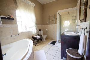 a bathroom with a tub and a sink and a toilet at Downstream in Dullstroom +6 photos