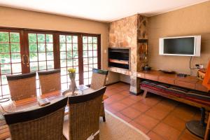 a living room with a table and chairs and a television at Downstream in Dullstroom