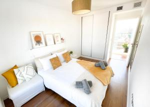 una camera da letto bianca con un letto e un divano di Ático mejores vistas al Pilar jacuzzi y garaje a Saragozza