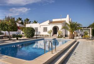 a swimming pool in front of a house at La Casa Del Sol in Torrevieja