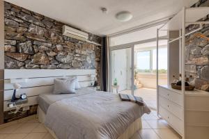 ein Schlafzimmer mit einer Steinmauer und einem Bett in der Unterkunft Casa LEX in Playa del Ingles