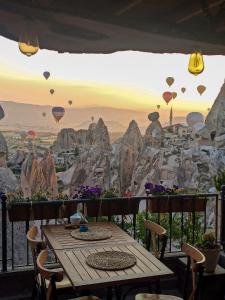 a table on a balcony with a view of balloons at Zen Cappadocia in Uchisar