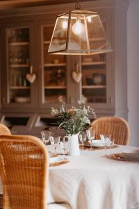 une table à manger avec une nappe et des chaises blanches dans l'établissement Gîtes du Bulz, en pleine forêt proche de la mer, à Pleyber-Christ