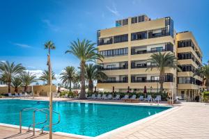 un hotel con piscina frente a un edificio en Casa LEX, en Playa del Inglés