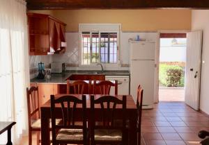 La cuisine est équipée d'une table, de chaises et d'un réfrigérateur. dans l'établissement Fuente del Gallo Nomada, à Conil de la Frontera