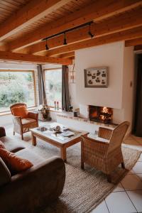 sala de estar con sofá, mesa y chimenea en Gîtes du Bulz, en pleine forêt proche de la mer, en Pleyber-Christ