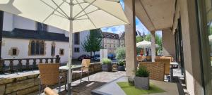 un patio con mesa y sombrilla en Hotel Aspethera en Paderborn