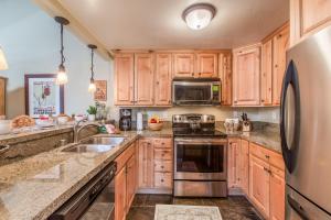 a kitchen with wooden cabinets and a stainless steel refrigerator at Courchevel 14 Remodeled Light and Bright Mountain Cabin, Walk to Canyon Lodge Slopes in Mammoth Lakes +18 photos