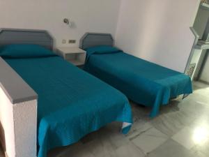 Pokój z 2 łóżkami z niebieskimi narzutami w obiekcie Club Atlantis studio 154 - Playa de Las Americas w Adeje