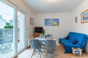 a living room with a table and chairs at Les Voiles - appartement avec terrasse - plage à 50 m in Pléneuf-Val-André