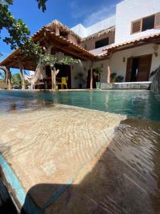 a swimming pool in front of a house at Pousada Fortal Preá in Prea